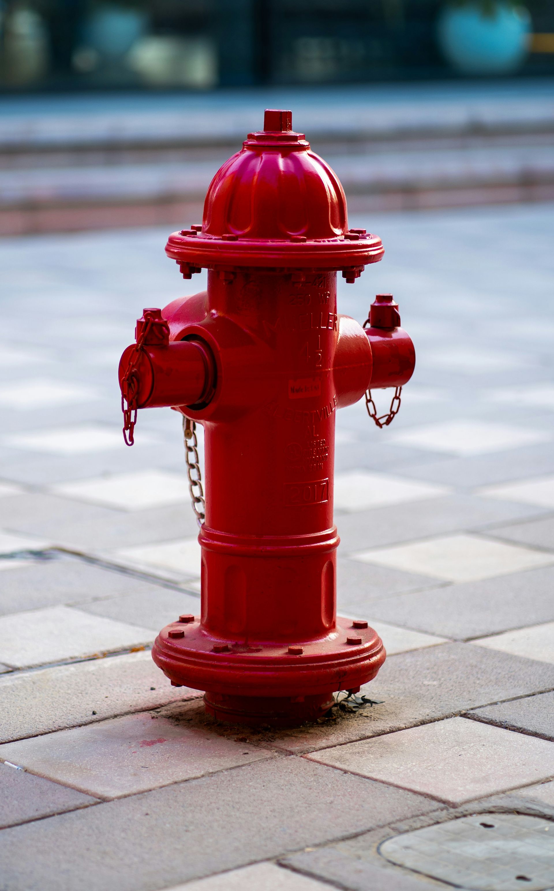 A red fire hydrant sitting on top of a sidewalk